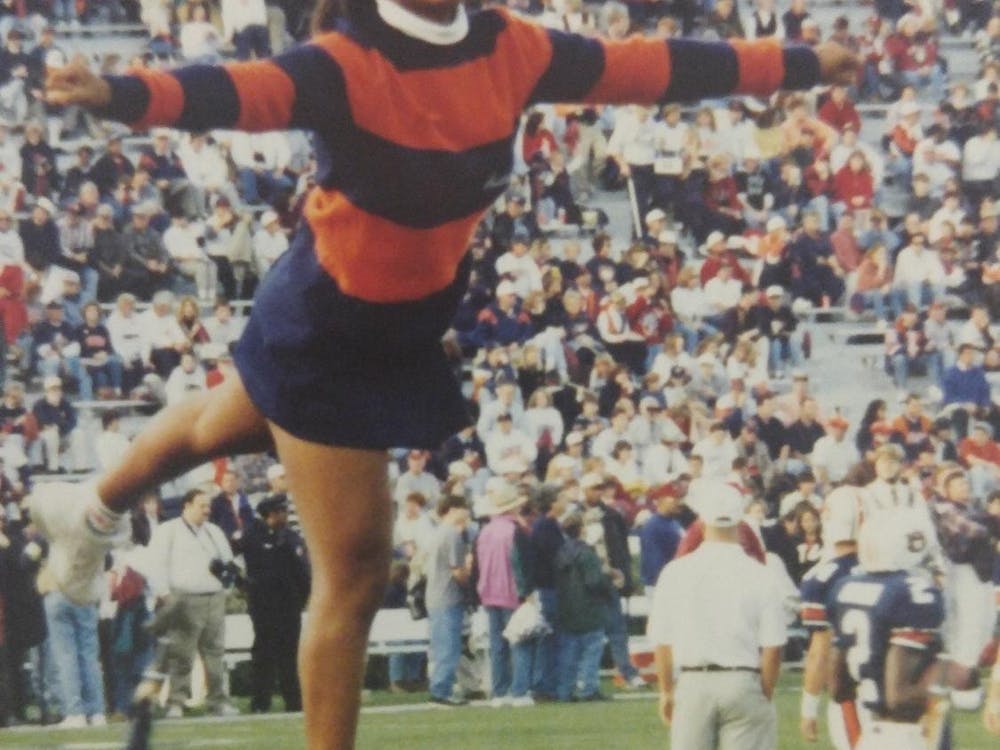 Wearing an orange and blue sweater, Danyelle Hillman is lifted and poses for a stunt. Contributed by Danyelle Hillman.