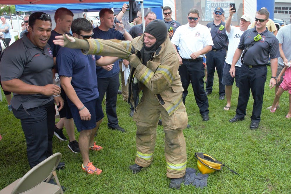 Opelika firefighters cheer on their relay team&nbsp;as they win the Big Bite Battle on Saturday, June 2, 2018 in Opelika, Ala.&nbsp;