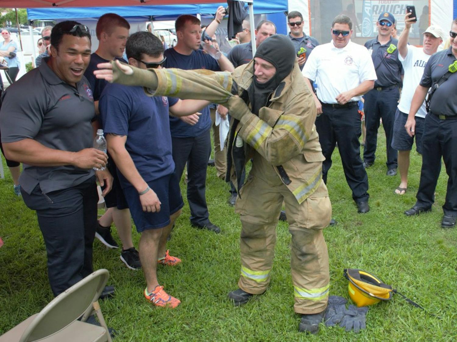 Opelika firefighters cheer on their relay team as they win the Big Bite Battle on Saturday, June 2, 2018 in Opelika, Ala. 