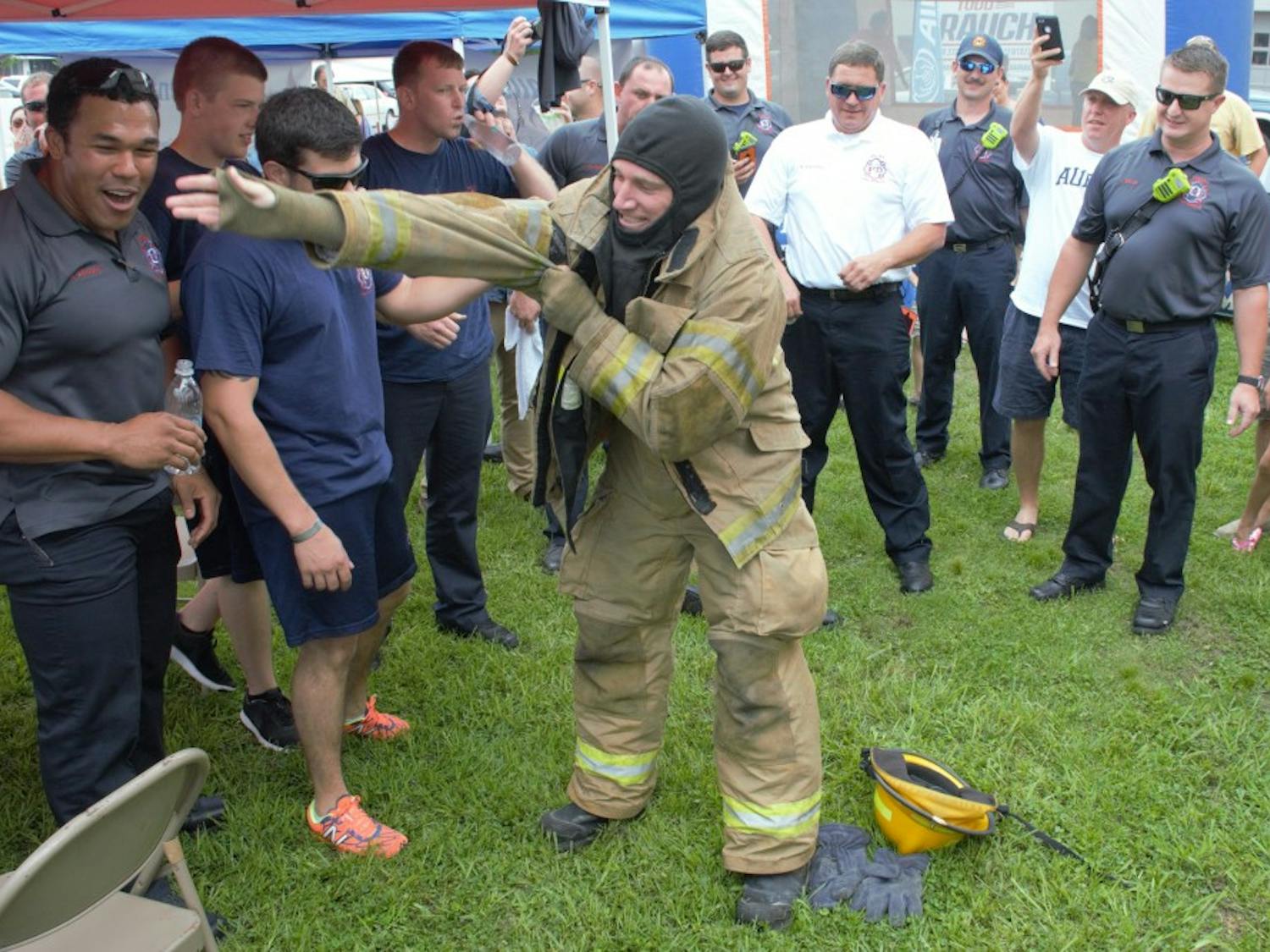 Opelika firefighters cheer on their relay team&nbsp;as they win the Big Bite Battle on Saturday, June 2, 2018 in Opelika, Ala.&nbsp;