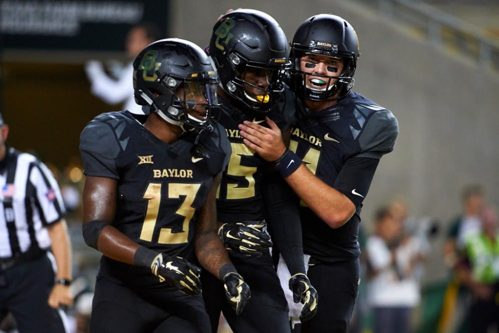Denzel Mims #15 of the Baylor Bears celebrates after scoring a touchdown with teammates Tony Nicholson #13 and Zach Smith #11 against the Oklahoma Sooners during the second half at McLane Stadium on September 23, 2017 in Waco, Texas.