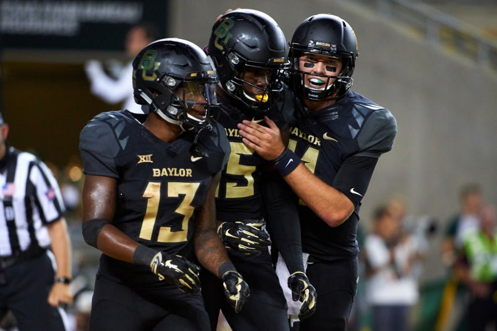 <p>Denzel Mims #15 of the Baylor Bears celebrates after scoring a touchdown with teammates Tony Nicholson #13 and Zach Smith #11 against the Oklahoma Sooners during the second half at McLane Stadium on September 23, 2017 in Waco, Texas.</p>