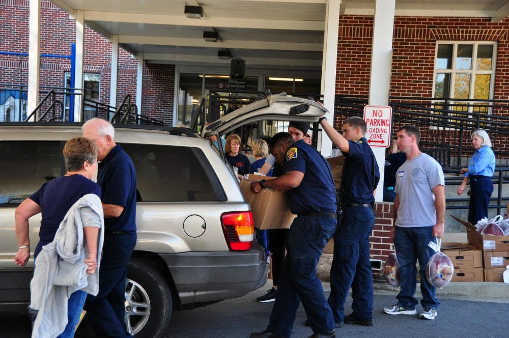 Auburn firefighters and community members&nbsp;place Thanksgiving food boxes in a car at Auburn United Methodist Church on Friday, Nov. 18, 2016.