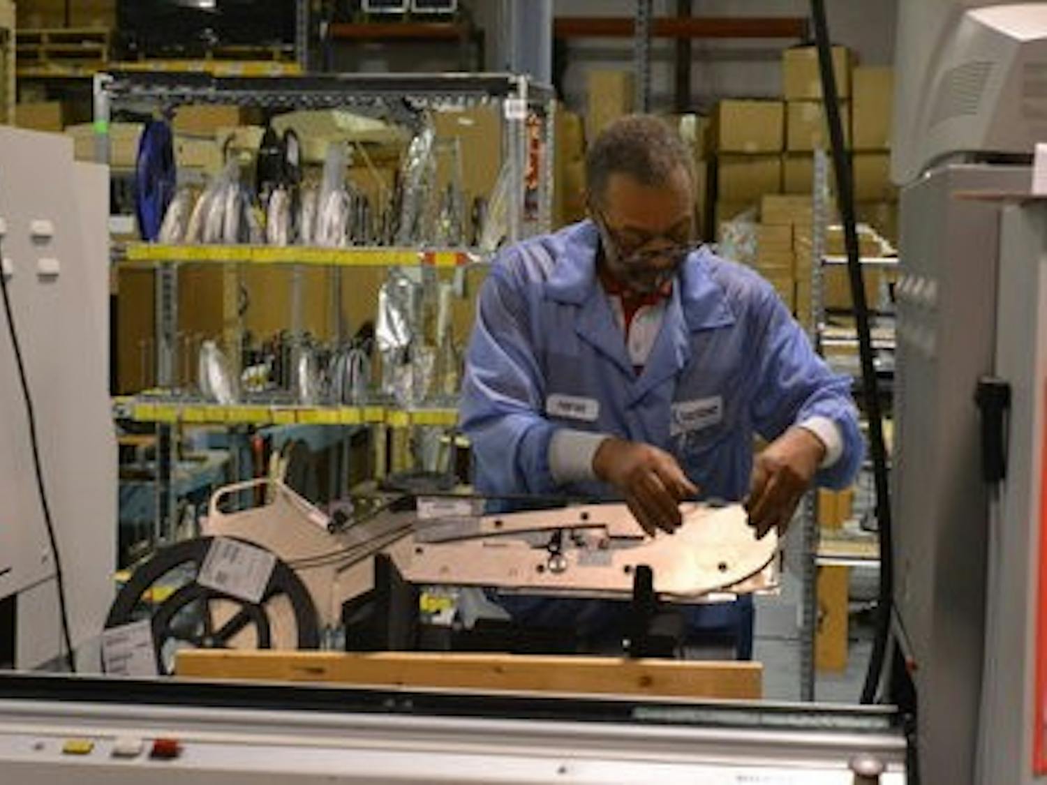 Harold Marshall, surface-mount technology operator, continues his work on manufacturing circuit boards for CoachComm. (Danielle Lowe / PHOTO EDITOR)