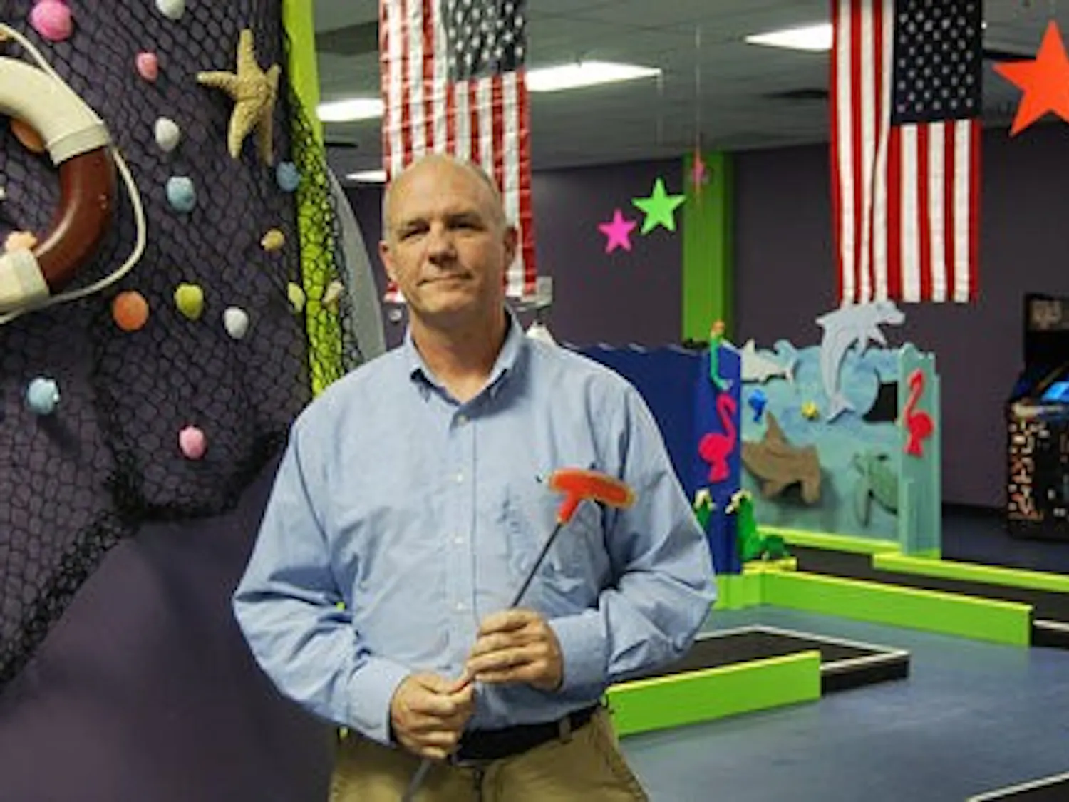 Doug Long stands in his American-themed, 18-hole indoor mini-golf course.