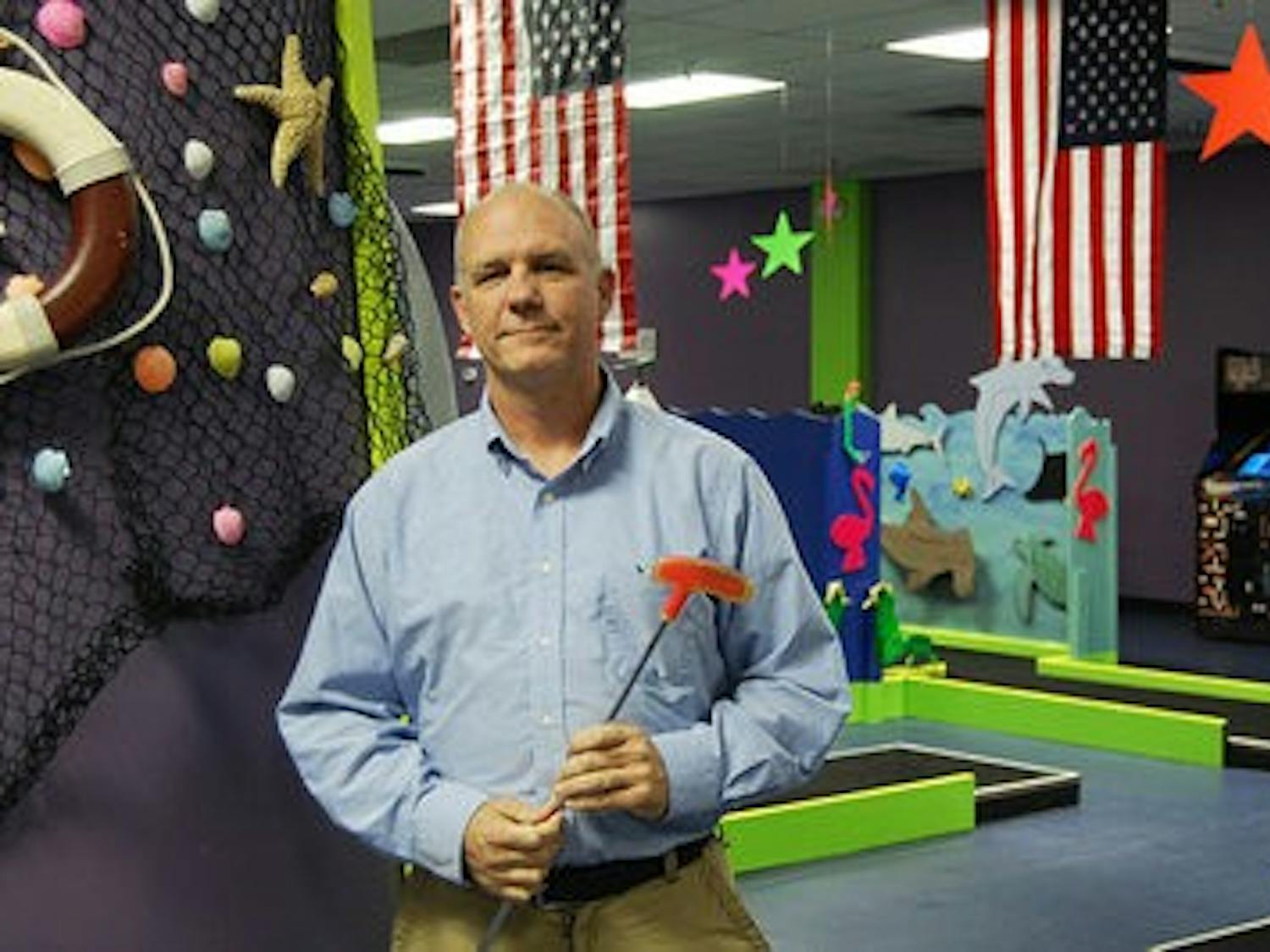 Doug Long stands in his American-themed, 18-hole indoor mini-golf course.
