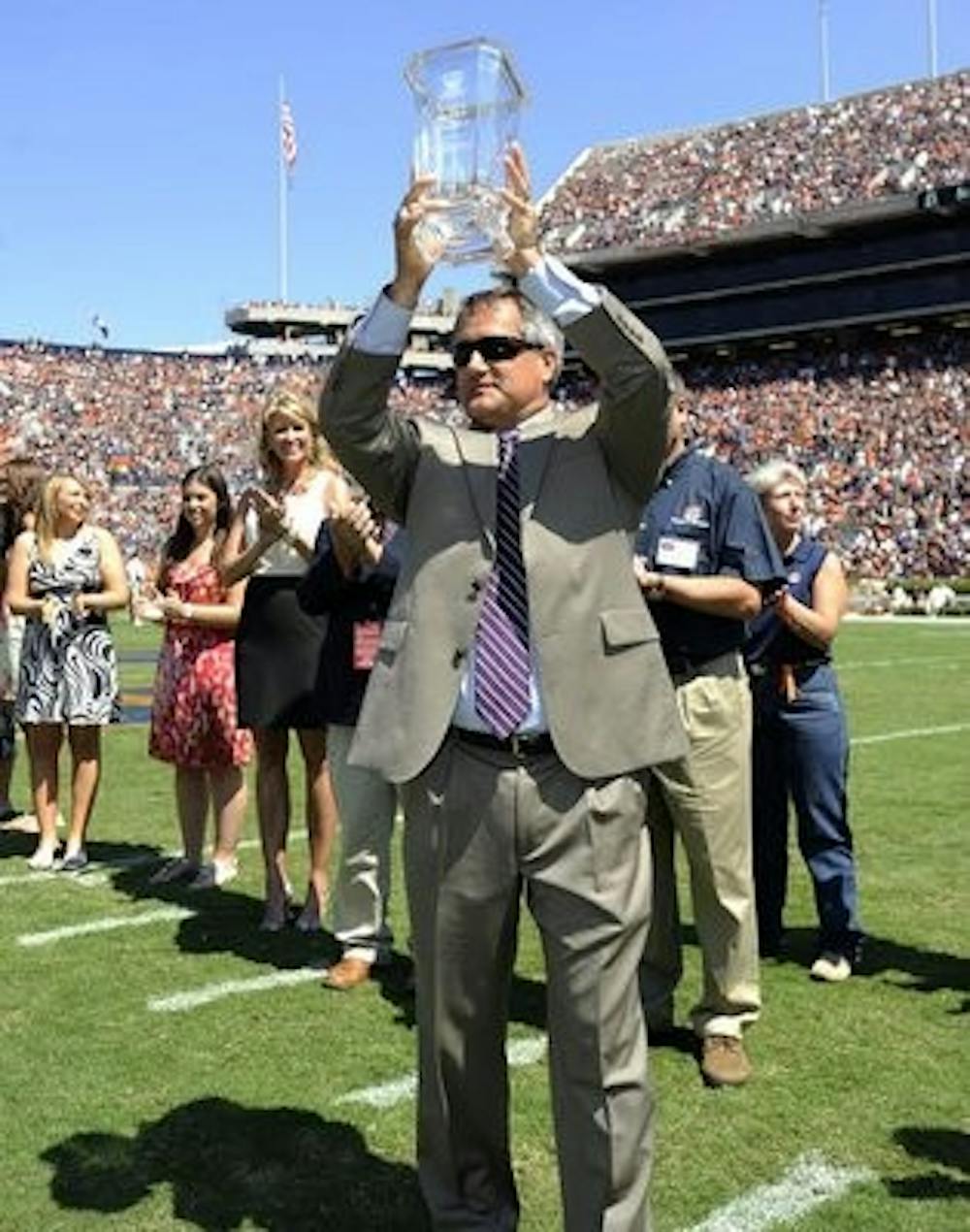 Auburn equestrian head coach Greg Williams holds up the NCEA Championship trophy in 2013 (Auburn Athletics)