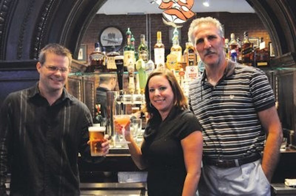 (L-R): General manager Chris McBride and bartender Brooke Mobley toast opening night with co-owner Joseph Garofalo, Monday. (Christen Harned / Assistant photo editor)