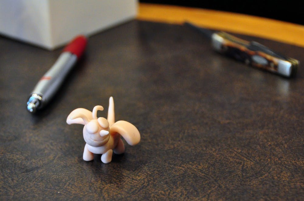 Ari Gutman, Auburn University lecturer, finishes a clay sculpture of a bee at Mama Mocha's Coffee Emporium in Auburn, Ala., on Wednesday, April 19, 2017.