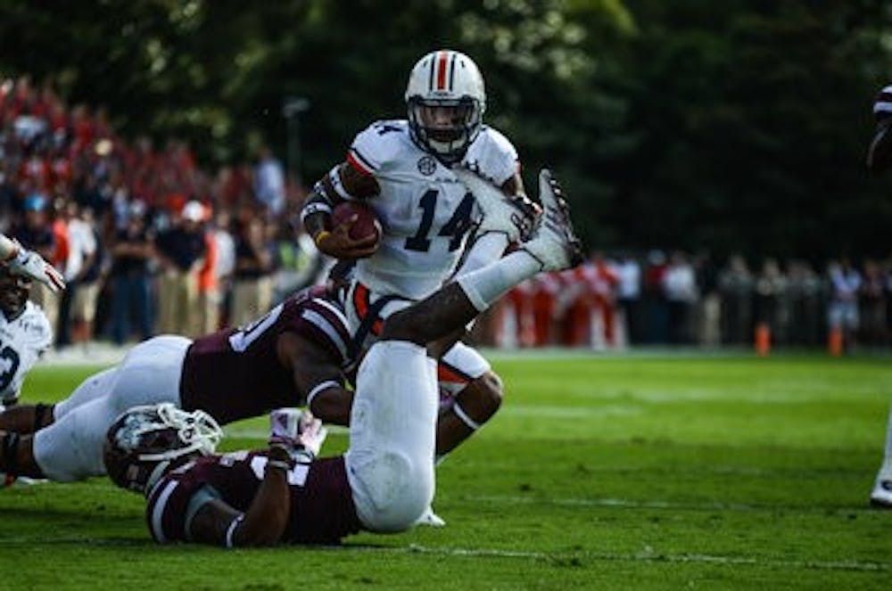 Nick Marshall attempts to outrun the MSU defenders.

Raye May / PHOTO EDITOR