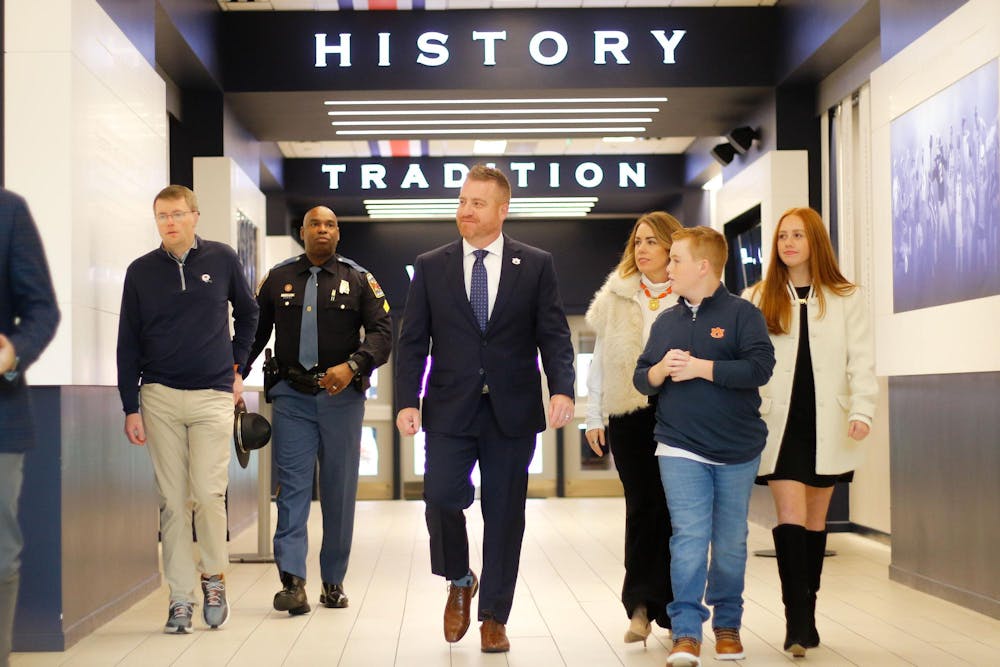 <p>Newly hired football coach Alex Golesh enters his first Auburn press conference with his family on Dec. 1, 2025.</p>