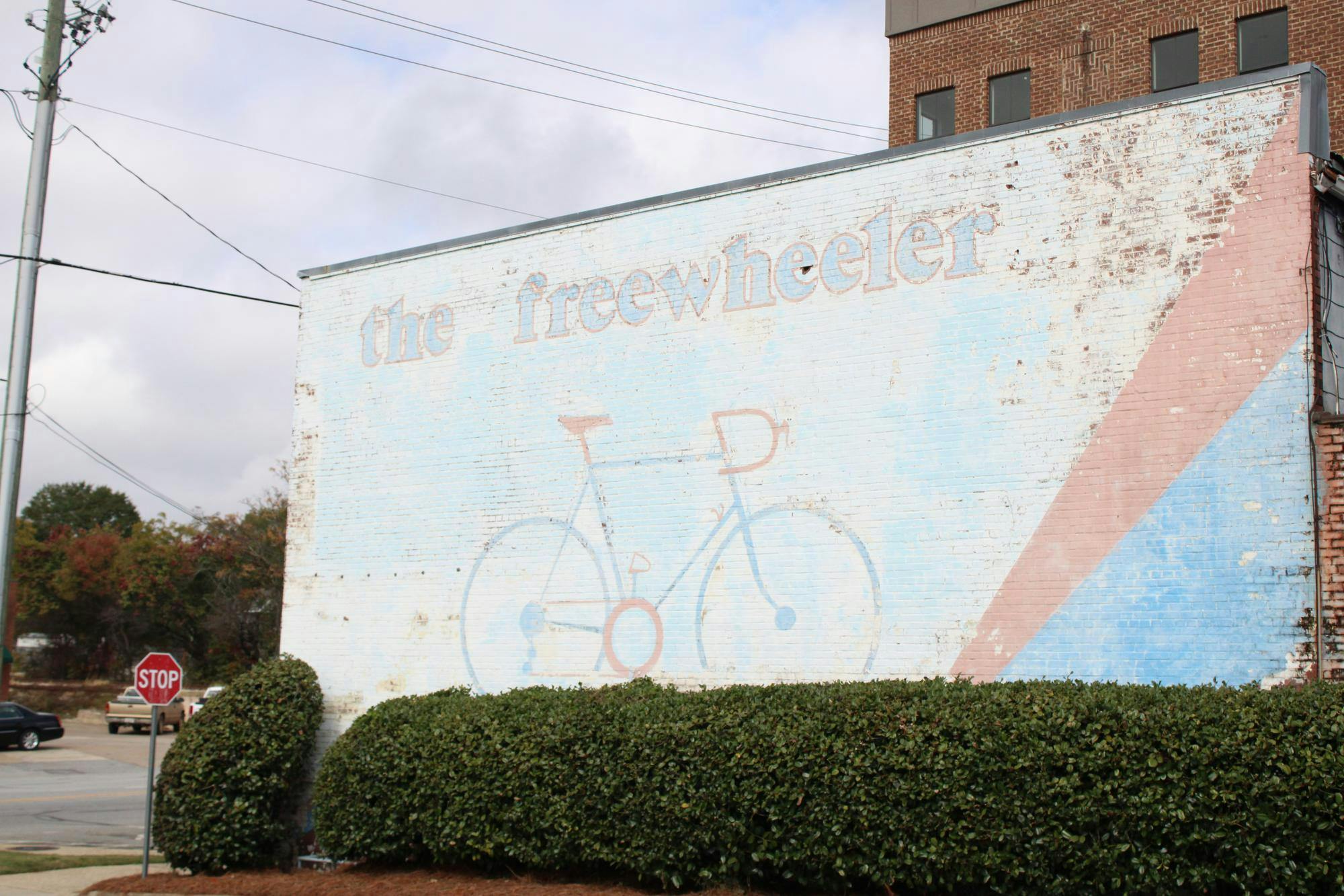 "the freewheeler", a mural depicting a bicycle located on a wall right next to Guthries on S College St.