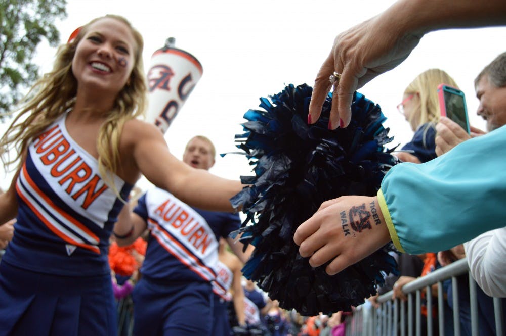 Auburn cheerleader Sommer Henry high fives fans during Tiger Walk. Auburn vs San Jose in Auburn, Alabama on Oct. 3. 