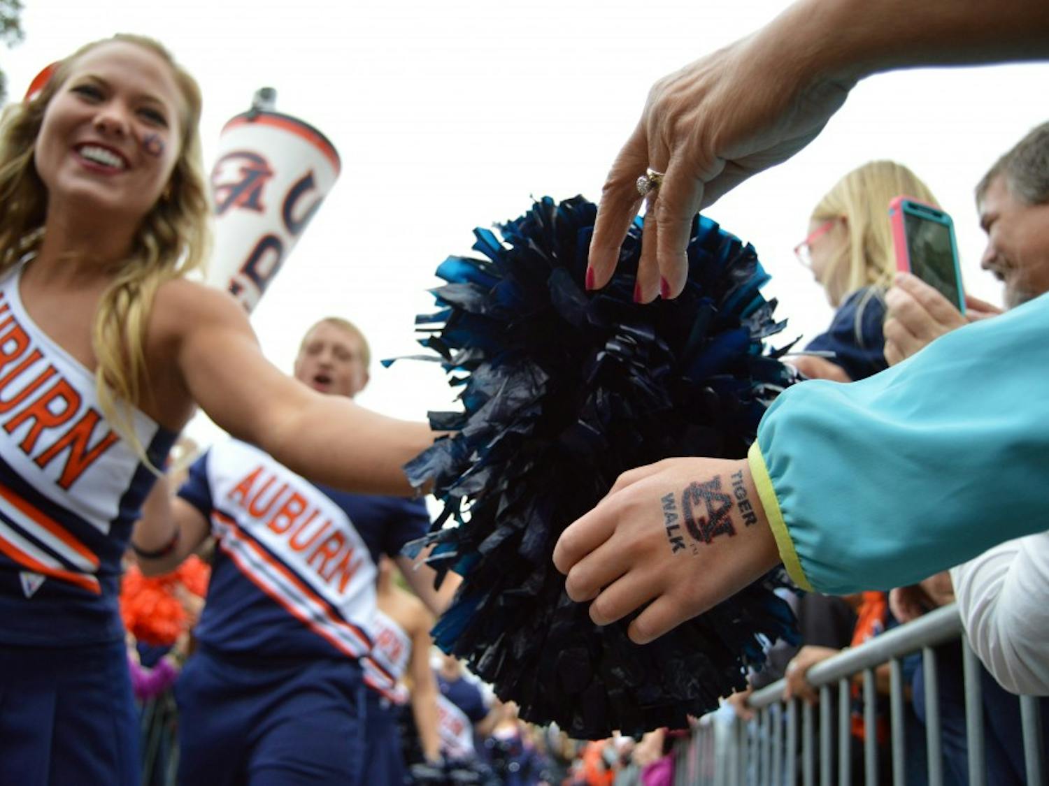 Auburn cheerleader Sommer Henry high fives fans during Tiger Walk. Auburn vs San Jose in Auburn, Alabama on Oct. 3. 