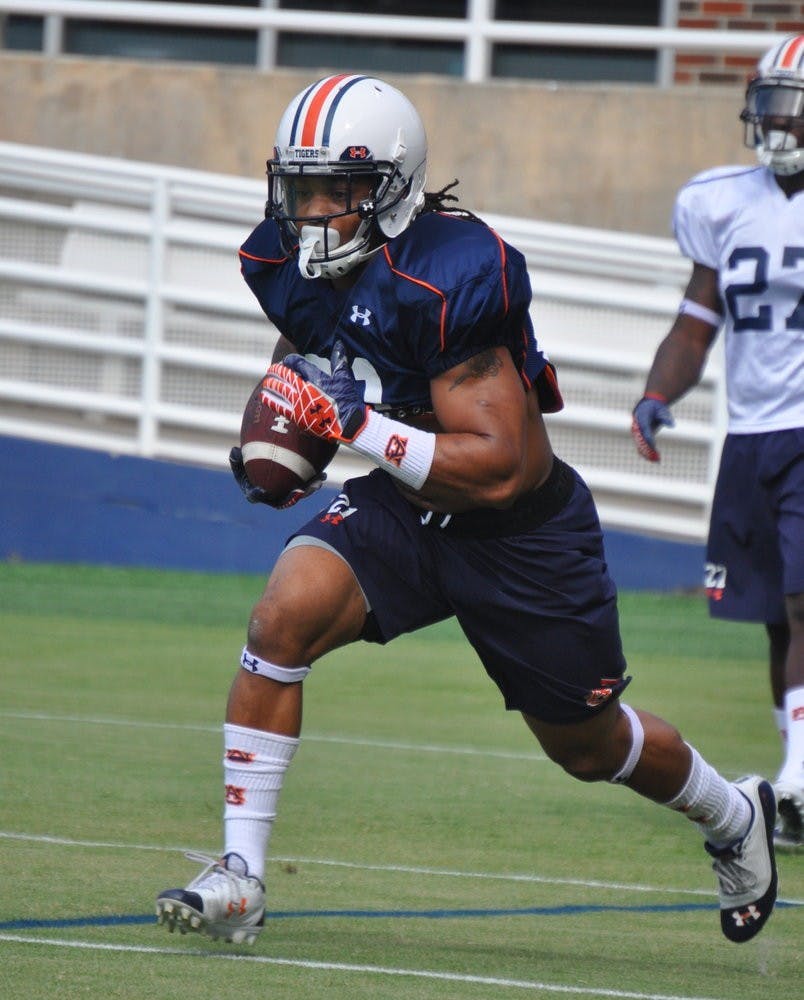 Running back Tre Mason takes the ball up the field during a drill on Monday.
Anna Grafton / ASSOCIATE PHOTO EDITOR