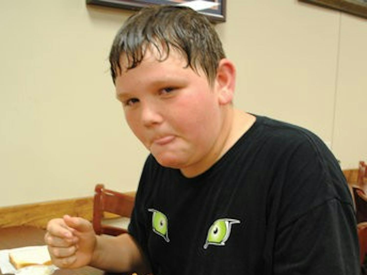 Ryan Johnson, 13, of Drake Middle School, munches on some chicken fingers Sunday at Louie's Chicken Fingers. (Maria Iampietro / Associate Photo Editor)