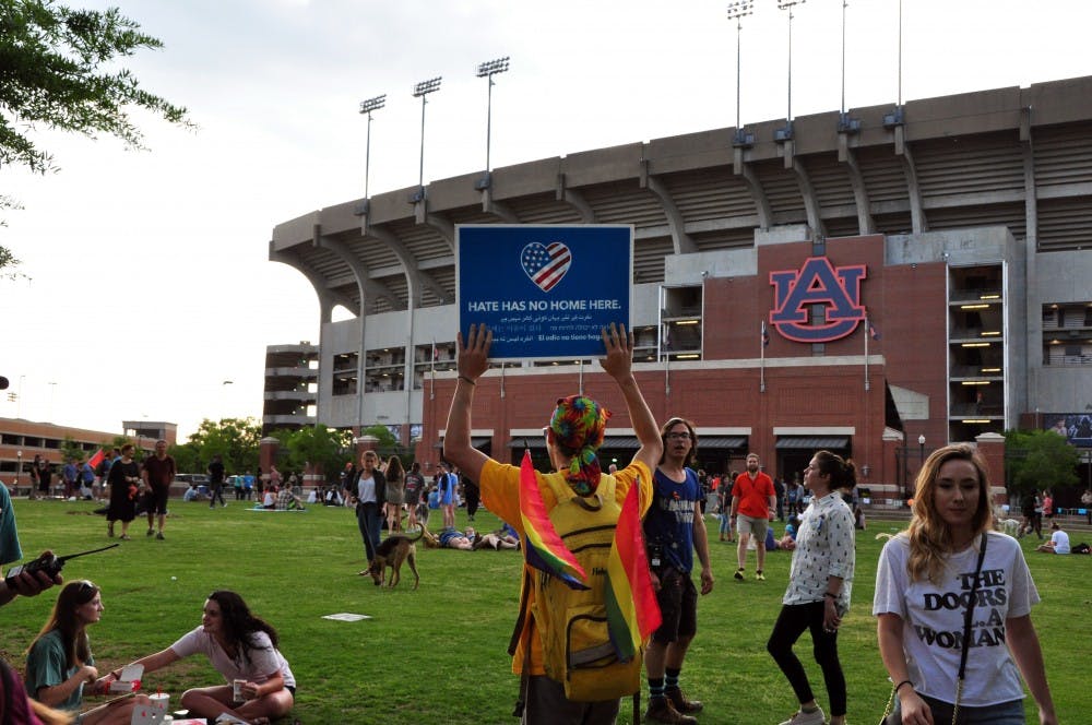 Billy Welburn, 2012 graduate, walks onto the Green Space&nbsp;with a sign reading "Hate has no home here" in several languages on Tuesday, April 18, 2017, in Auburn, Ala. Students congregated on the Green Space for the Auburn Unites concert, which was held to protest white nationalist Richard Spencer, who spoke on campus the same evening.