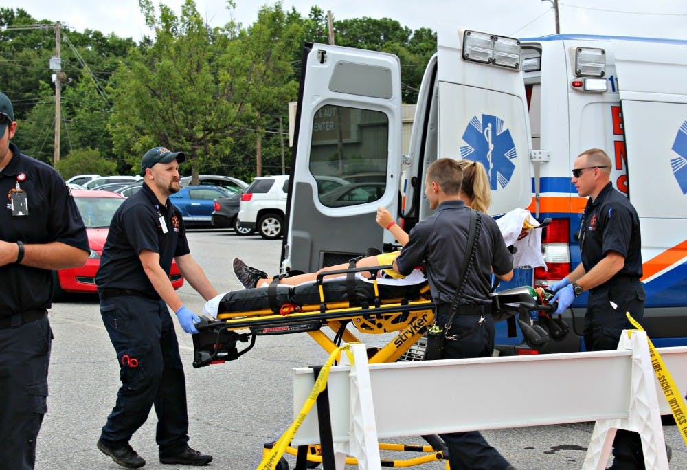 <p>Opelika Emergency Medical Services loading a patient into the ambulance at EAMC's Disaster Drill on Tuesday, June 6, 2017 in&nbsp;Opelika, Ala..</p>