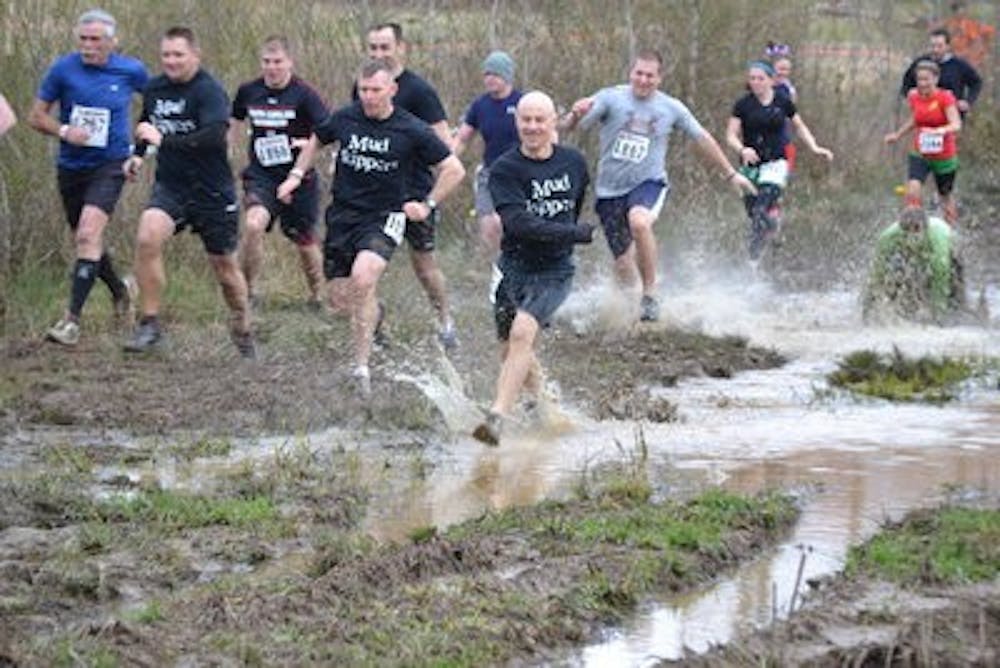 Participants race to a muddy victory. (Raye May / PHOTO EDITOR)