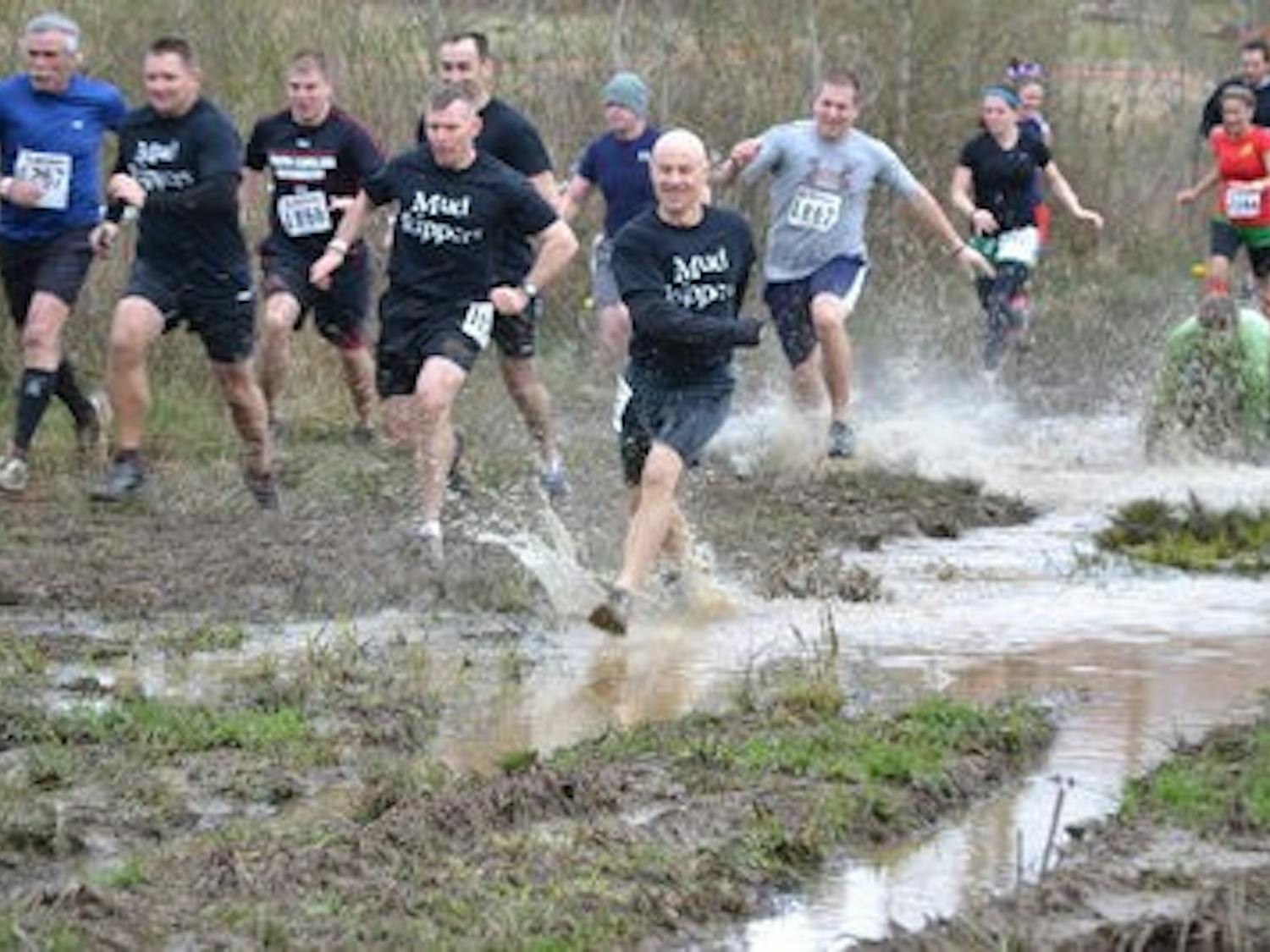 Participants race to a muddy victory. (Raye May / PHOTO EDITOR)