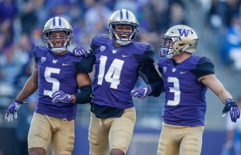 Defensive back Myles Bryant #5 of the Washington Huskies celebrates with defensive back Jojo McIntosh #14 and defensive back Elijah Molden #3 after recovering a fumble against the UCLA Bruins at Husky Stadium on October 28, 2017 in Seattle, Washington.