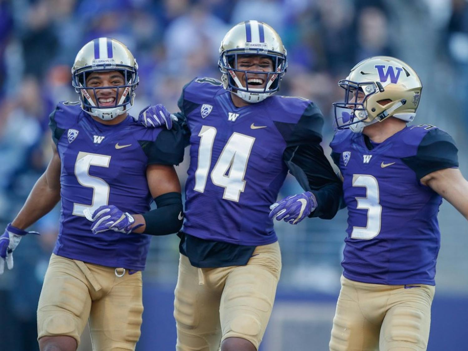 Defensive back Myles Bryant #5 of the Washington Huskies celebrates with defensive back Jojo McIntosh #14 and defensive back Elijah Molden #3 after recovering a fumble against the UCLA Bruins at Husky Stadium on October 28, 2017 in Seattle, Washington.