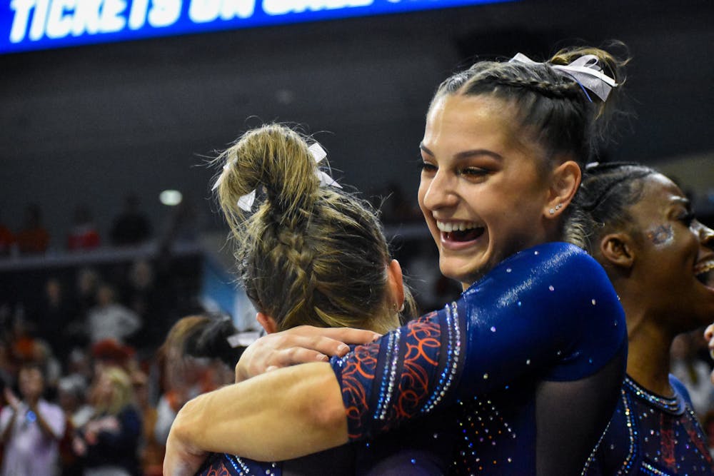 Cassie Stevens hugs a teammate after it was announced that Auburn would advance to the Elite 8 during the NCAA Women's National Gymnastics Sweet 16 in the Neville Arena in Auburn, Alabama.
