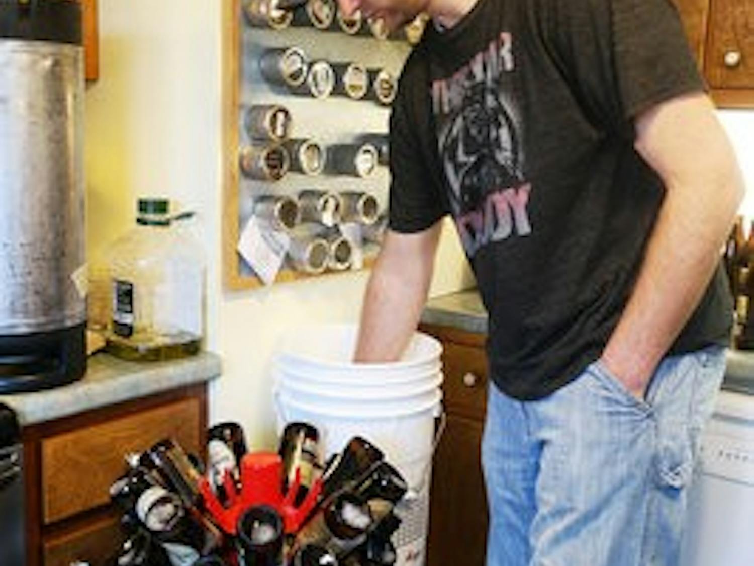 Kerry McGinnis sanitizes the bottles to be used for Red Clay brewery