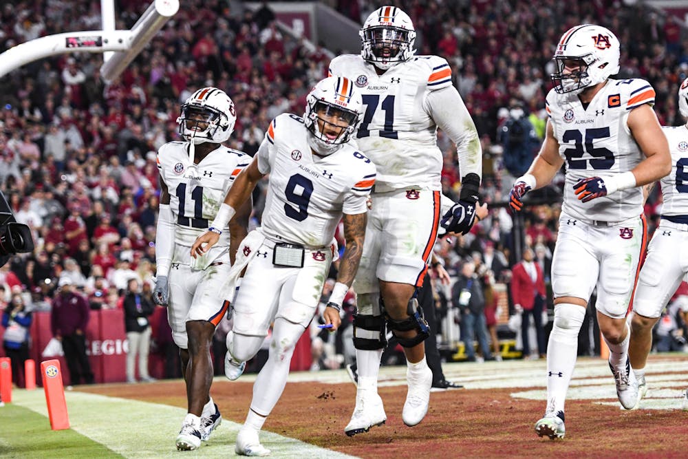 <p>Auburn quarterback Robby Ashford (9) celebrates with teammates after scoring a rushing touchdown in the first half against the Alabama Crimson Tide in Bryant-Denny Stadium on Nov. 26, 2022.</p>