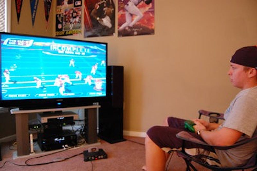 Mike Moody, senior in supply chain management, plays NFL Blitz 2001 on his Nintendo 64. (Charlie Timberlake / ASSISTANT PHOTO EDITOR)