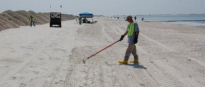 A BP contract worker rakes the public beach in Dauphin Island, Ala. on June 19, 2010. He explained that he was looking for tar balls the high tide might have brought in and buried during the night. (Brian Woodham / ASSOCIATE COPY EDITOR)