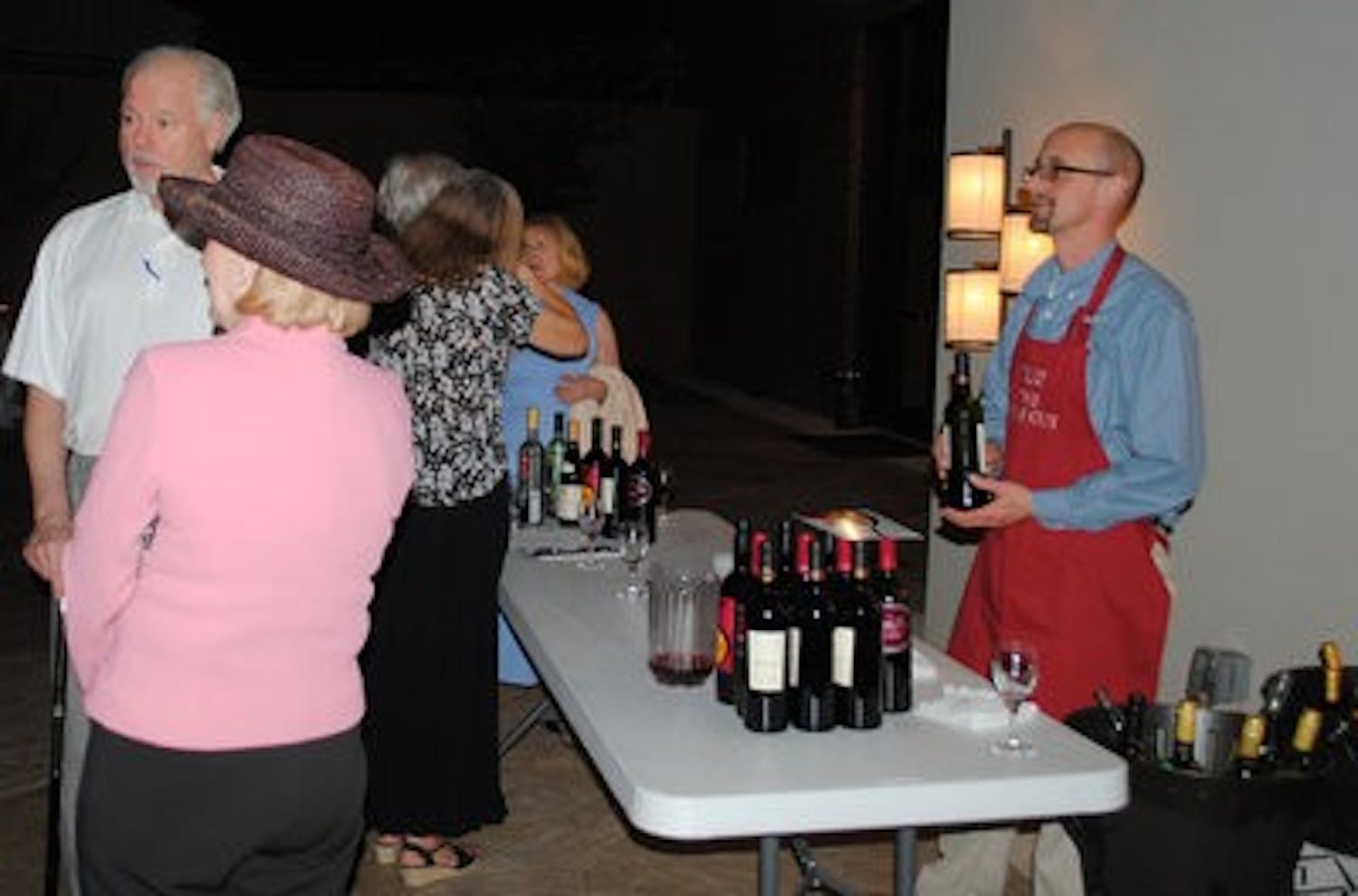 Andrew "Gus" Clark of Fine Wine and Beer by Gus serves wine at a wine tasting in downtown Opelika Thursday. (Elaine Busby / Assistant photo editor)