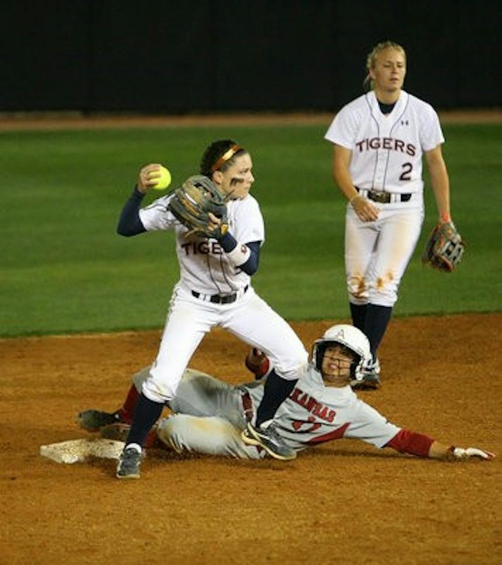 Second baseman Lauren Guzman turns a double play Friday night in the first of a three-game series against Arkansas. The Tigers won Friday and Saturday's games in the series. (Rebecca Croomes / PHOTO EDITOR)