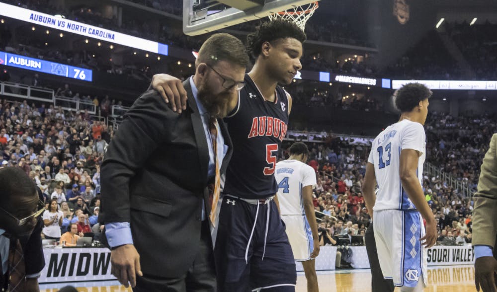<p>Chuma Okeke (5) is helped off the court during Auburn basketball vs. North Carolina in the Midwest Region semifinal of the 2019 NCAA Tournament on March 29, 2019, in Kansas City, Mo. Photo courtesy Lauren Talkington / The Glomerata. &nbsp;</p>