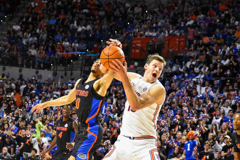 <p>Walker Kessler (13) gets contested in the paint in a match between Auburn and Florida in the Stephen C. O'Connell Center on Feb. 19, 2022, in Gainesville, Fla.&nbsp;</p>