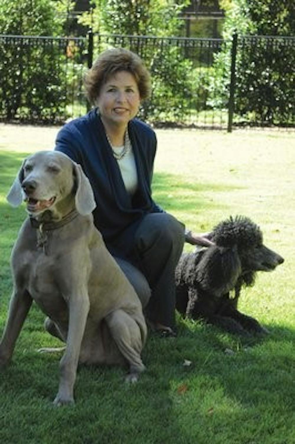 Susie Gogue plays with her dogs Pogo and Sophie in the backyard of the mansion Monday. (Christen Harned / Assistant Photo Editor)