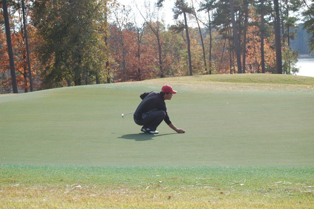 <p>A golfer lines up his putt on the 18th green. (File photo) </p>