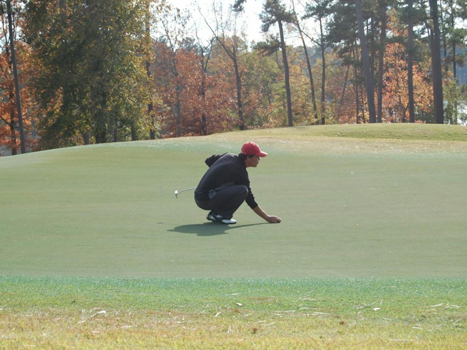 A golfer lines up his putt on the 18th green. (File photo)