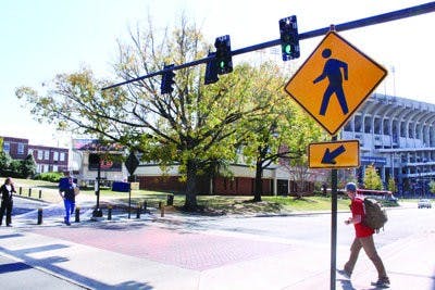 Students cross at one of two new stoplights on Donahue Drive. The lights and pedestrian signals are programmed for maximum traffic flow. (Alex Sager / ASSOCIATE PHOTO EDITOR)