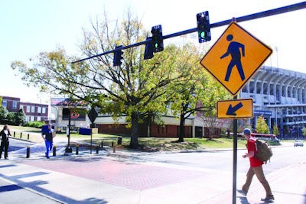 Students cross at one of two new stoplights on Donahue Drive. The lights and pedestrian signals are programmed for maximum traffic flow. (Alex Sager / ASSOCIATE PHOTO EDITOR)