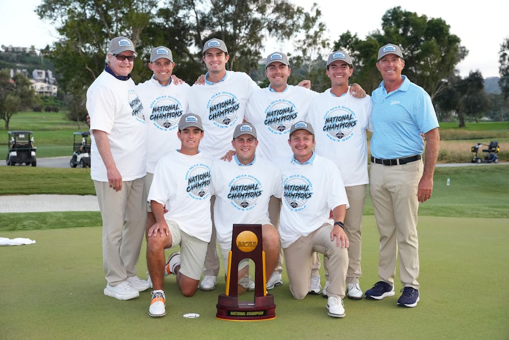 <p>Auburn men's golf poses with its national championship trophy.&nbsp;</p>
