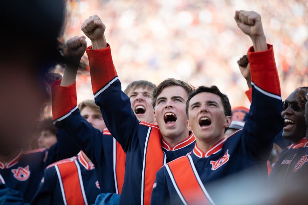 <p>Members of the Auburn Marching Band cheering at the sight of the F-35 flyover during the 2023 Iron Bowl game</p>