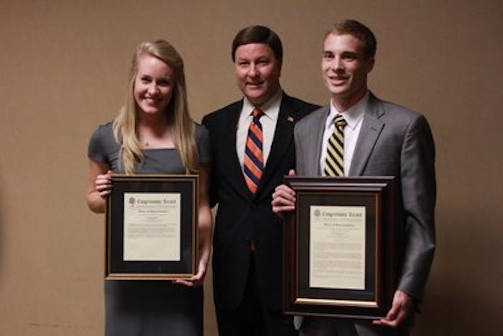 Tara Jones and Elliott Lynn receiving awards from Congressman Mike Rogers.