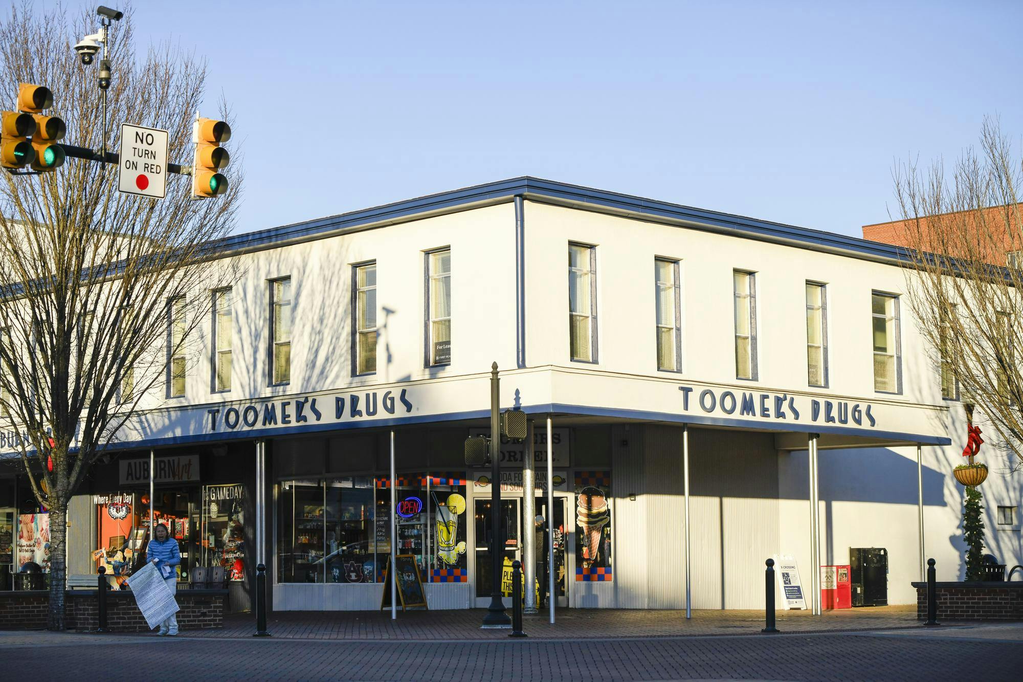 A white building with multiple windows features a pharmacy sign.