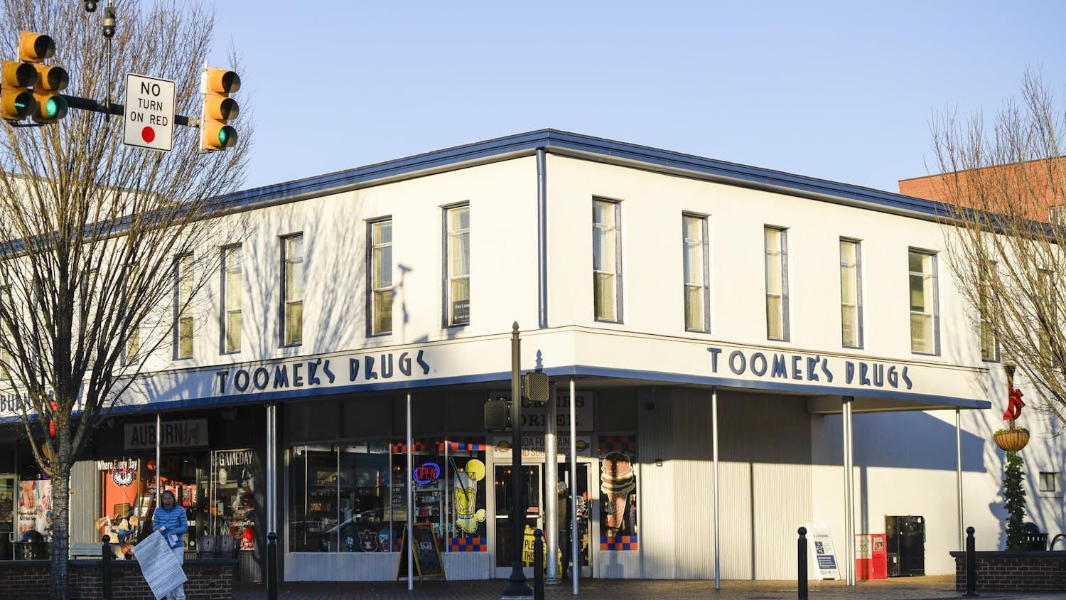 A white building with multiple windows features a pharmacy sign.