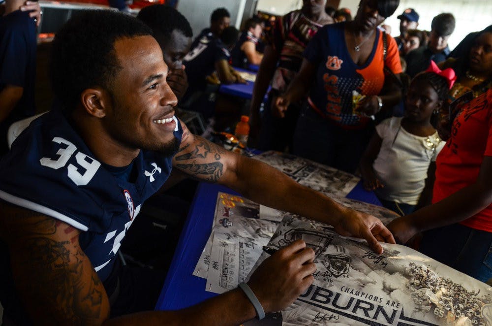 Defensive back Tray Matthews signs a poster. (File photo)