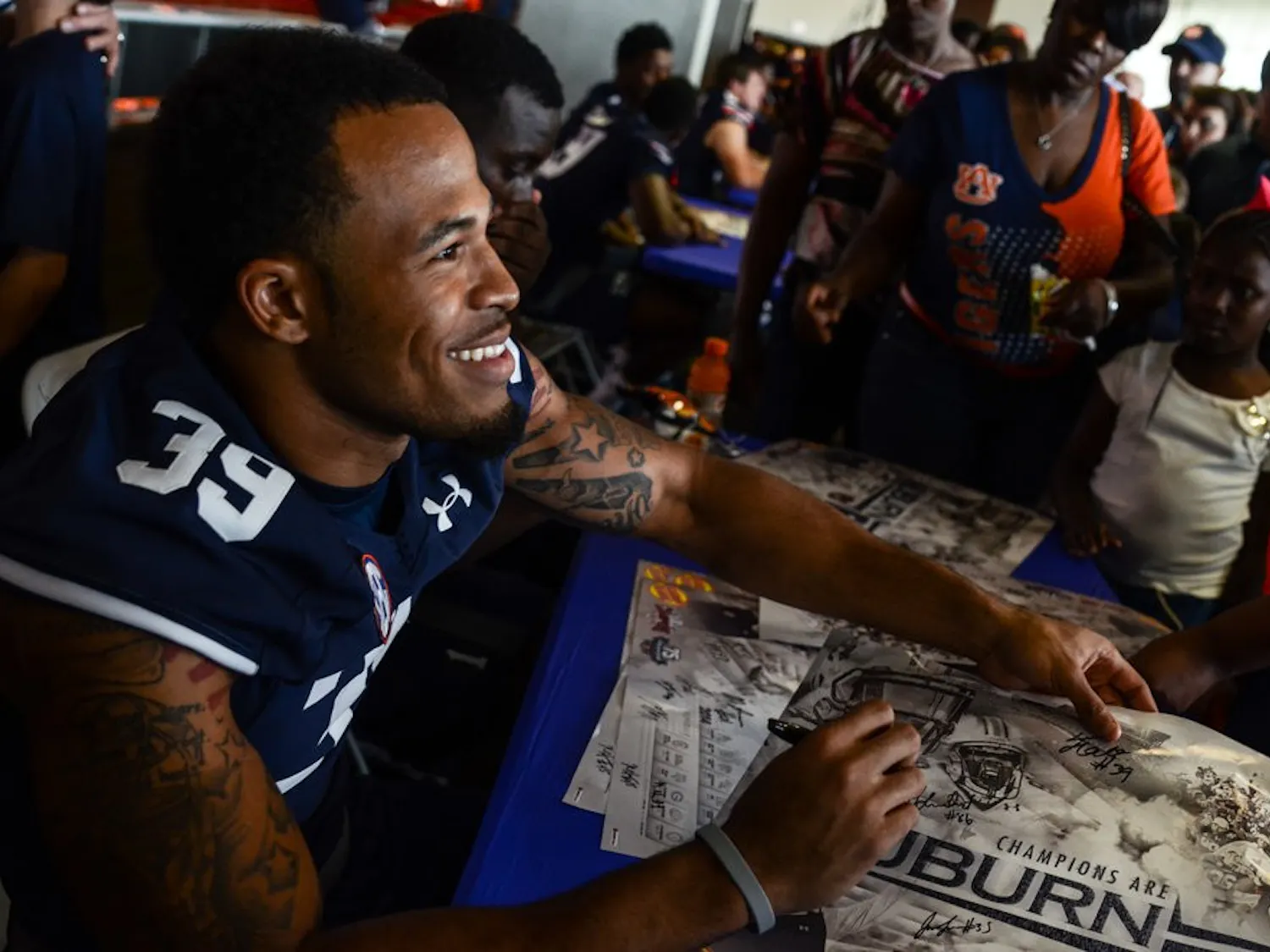 Defensive back Tray Matthews signs a poster. (File photo)