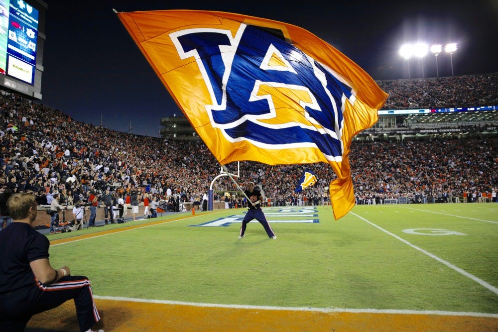 <p>Trenton White waves the flag after Auburn scores a touchdown in Jordan-Hare Stadium on Oct. 22, 2016.</p>