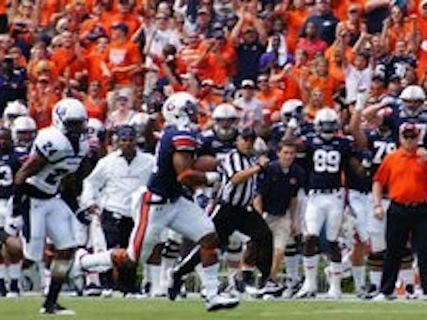 Auburn fans cheer as freshman running back Tre Mason sprints past Utah State defenders for a 97-yard kickoff return for a touchdown in the second quarter Saturday. (Robert E. Lee / ASSISTANT CAMPUS EDITOR)