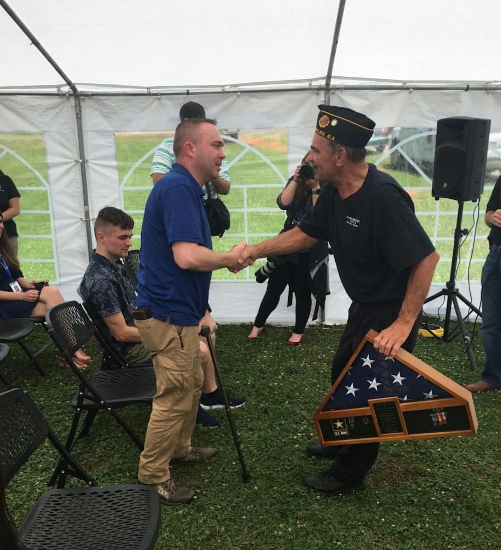 <p>Retired Sgt. Adam Lee shakes hands with a representative from American Legion as he presents Lee with&nbsp;a plaque of appreciation Wednesday, May 30, 2018.&nbsp;</p>